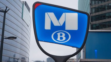 BRÜKSEL, BELGIUM - 26 Kasım 2025 - Brüksel 'de bir çağdaş mimari zeminine karşı ikonik metro B tabelası