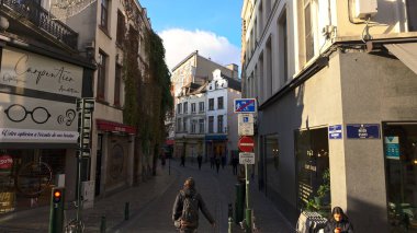 BRÜKSEL, BELGIUM - 26 Kasım 2025 - Brüksel 'de tarihi Avrupa mimarisi ile dar bir sokakta yürüyen insanlar