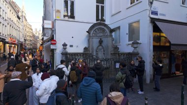 BRÜKSEL, BELGIUM - 26 Kasım 2025 - Brüksel 'de popüler bir kent simgesi olan Manneken Pi heykelinin etrafında toplanan turistler