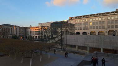 BRÜKSEL, BELGIUM - 26 Kasım 2025 - Mont des Arts 'ta yürüyen insanlar, tarihi mimariyi günbatımında modern yapılarla harmanlıyor