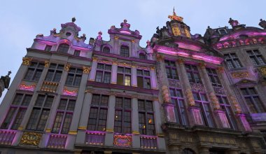 BRÜKSEL, BELGIUM - 26 Kasım 2025 - Brüksel 'deki tarihi Grand Place' in alacakaranlıkta aydınlanan dekoratif lonca mimarisi