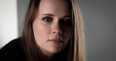 Yeşil gözlü güzel sarışın bir kadının stüdyo portresi. Bu moda ve güzellik fotoğrafçılığı gri arka planda genç bir mankenin yakın çekimini gösteriyor..