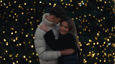 Genç bir çift, Paris 'te bir Noel ağacı ve ışıklarıyla sevgiyle kucaklaşıyor. Romantik bir zemin sağlıyor. Bu resim seyahat turizmi ve tatil temalı ticari projeler için uygundur..