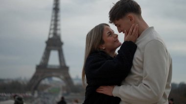 Romantik bir çift Paris 'te Fransa' da Eyfel Kulesi 'nin arka planında sevgi ve şefkati ifade eden bir kuleyle kucaklaşıyor. Bu resim seyahat turizmi ve ilişki kavramları için uygundur.