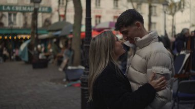 Paris 'in Montmartre bölgesinde romantik bir çift sarılıyor Paris mimarisi ve kaldırım taşı sokakları sevgi ve sevgiyi aktarıyor..