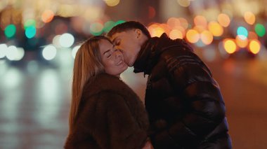 Romantik bir çift Paris 'te geceleri Fransa' da öpüşüyor ve arka planda Bokeh ışıkları var. Bu resim, bir Avrupa şehrinde aşk seyahatini ve ilişkileri göstermek için kullanılabilir..