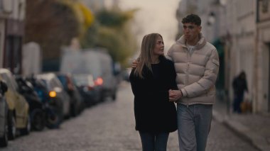 Romantik bir çift Paris 'te bir sokakta birlikte yürüyor Fransa' da sevgi ve sevgiyle kucaklaşıyorlar. Bu resim Avrupa kenti yaşam tarzı ilişki hedeflerini veya seyahat temalarını göstermek için kullanılabilir.