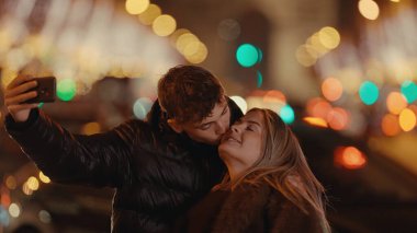 Romantik bir çift gece Paris 'te arka planda bokeh ışıkları olan bir selfie çeker. Resim, sevgi ve seyahat sevgisi taşır. Seyahat yaşam tarzı ve ilişki temaları için kullanılabilir..