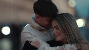 Romantik bir çift Paris 'te gecenin bir yarısı Bokeh ışıklarıyla sarılıyor. Sevecen genç aşıklar şehir ortamında sevgi ve romantizm gösteriyorlar..