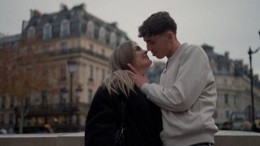 Romantik genç bir çift, Paris 'te bir şehir manzarasına karşı sevgi ve sevgiyle sarılıyor. Bu resim seyahat ilişkilerinin ve Avrupa seyahatlerinin özünü yansıtır.