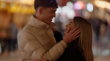 Romantik bir çift gece Paris 'te Bokeh ışıklarıyla sarılır. Genç adam ve kadın sevgililer günü için bu görüntüyü uygun hale getirirler..
