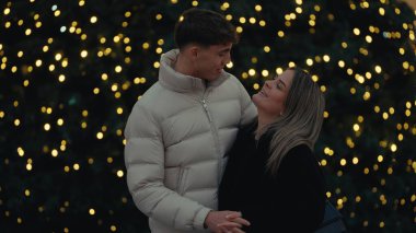 Paris 'te birbirine aşık genç bir çift, bir Noel ağacı ve şenlik ışıklarıyla romantik bir zemin oluşturarak Fransa' yı kucaklıyor. Bu görüntü seyahat turizmi ve tatil temalı kampanyalar için mükemmel..