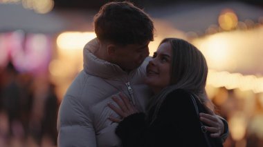 Genç bir çift, Paris 'te, gece vakti, romantik bir ortam yaratarak, sevgi dolu bir şekilde sarılır. Bu görüntü, seyahat yaşam tarzı ve ilişki teması için uygun olan bir yakınlık ve aşk anını yakalar..