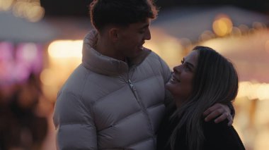 Genç bir çift gece Paris 'te Bokeh ışıklarıyla sarılıp romantik bir ortam yaratıyor. Bu görüntü, kış mevsiminde seyahat ve ilişki temalarına uygun sevgi ve sevgiyi aktarıyor..