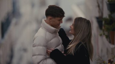 Genç bir çift, Fransa 'da bir Paris caddesinde sevgi ve şefkat göstererek şefkatle kucaklaşır. Bu görüntü seyahat romantizmi ya da yaşam tarzı içeriği için uygundur..