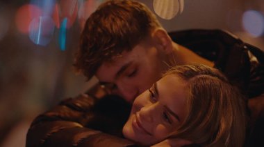 Romantik genç bir çift, Paris 'te geceleri Fransa' ya sarılır. Bokeh ışıkları sıcak ve samimi bir atmosfer yaratır. Bu resim aşk seyahatleri ve ilişkileri resmetmek için mükemmel..