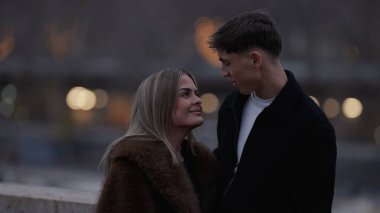 Paris 'te genç bir çift, gece vakti romantik bir anı paylaşıyor. Resim, seyahat yaşam tarzı ve ilişki içeriği için uygun bir şehir ortamında sevgi ve şefkat sergiliyor..