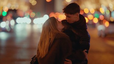 Paris 'te romantik bir çift, gece Fransa' da arka planda Bokeh ışıkları ile sarılır. Bu görüntü aşk sevgisini ve şehir romantizminin seyahat ve ilişki temalarına uygun büyüsünü aktarır..