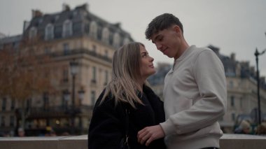 Romantik bir çift, Paris 'te birbirlerine sevgi ve sevgiyle bakıyor. Fransa şehir manzarası, seyahat ve yaşam tarzı içeriği için güzel bir zemin sağlıyor..