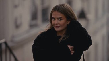 Paris 'te arka planda bir binayla poz veren siyah ceketli çekici bir kadın. Bu görüntü, moda tarzı seyahat ve turizm içeriği için uygundur.