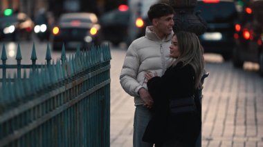 Arka planda şehir trafiği olan bir Paris caddesinde romantik bir çift birbirine sarılıyor. Görüntüler, popüler bir tatil beldesinde sevgi ve şehir yaşam tarzını aktarıyor..