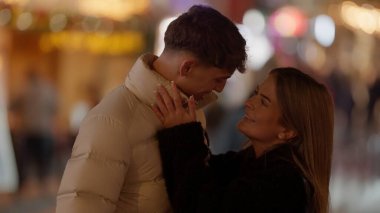 Paris 'te genç ve romantik bir çift, gece vakti Fransa' yı sarıp sarmalıyor. Görüntü, şehir romantizmi ve seyahat teması için ideal bir şehir ortamında sevgi ve şefkat yakalıyor..