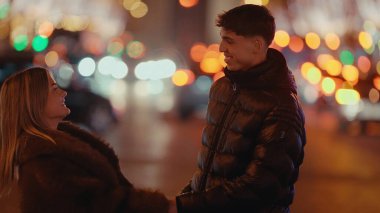 Paris 'te romantik bir çift gece Fransa' da Bokeh ışıkları altında el ele tutuşuyor. Bu resim seyahat turizm, aşk ve ilişki kavramları için kullanılabilir..