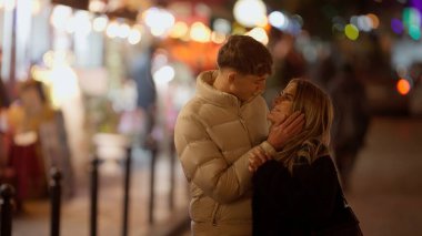 Romantik bir çift, Paris 'te geceleri Fransa' da sarılıp şehrin ışıklarıyla sevgi ve şefkat gösterirler. Bu resim seyahat ilişkileri ve yaşam tarzı kavramları için uygundur.