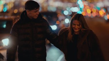 Genç bir çift gece Paris 'te romantik bir buluşmanın tadını çıkarırken şehir ışıkları arka planda güzel bir bokeh etkisi yaratarak samimi ve sevgi dolu atmosferi güçlendiriyor..