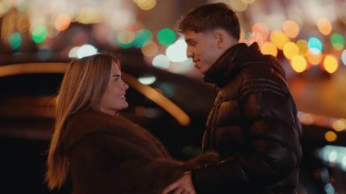 Paris 'te genç ve romantik bir çift. Arka planda Bokeh ışıkları olan bir çift. Sevgili ve sevgili, şehir turizminin ve seyahat deneyiminin tadını çıkarıyorlar..