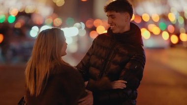 Genç bir çift Paris 'te geceleri Fransa' da sarılıyor ve arka planda Bokeh ışıkları var. Bu resim seyahat romantizmi ve ilişki temaları için kullanılabilir.