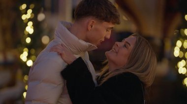 Paris 'te genç ve romantik bir çift gece Fransa' da sevgi ve şefkat gösteren bokeh ışıklarıyla sarılır. Bu resim Sevgililer Günü için mükemmel kış tatili ve romantik kavramlar için..