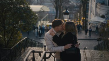 Sonbahar sezonu boyunca Paris 'te Montmartre' nin merdivenlerinde romantik bir çift öpüşür. Bu görüntü seyahat, turizm, hisse senedi fotoğrafçılığı ve yaratıcı içerik için mükemmel..