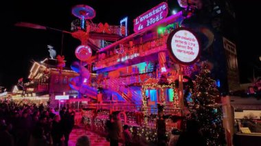 PARIS, FRANCE - 16 ARALIK 2025 - Kalabalık renkli tatil ışıkları ve dekorasyonlarıyla şenlikli bir kış fuarının tadını çıkarıyor