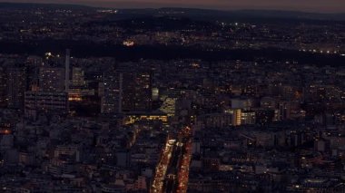 PARIS, FRANCE - 16 ARALIK 2025 - Alacakaranlıktaki Paris şehir manzarası şehir binalarını ve sokak trafiğini gösteriyor