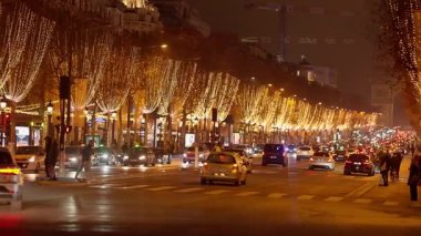 PARİS, FRANCE - 16 ARALIK 2025 - Ağacı aydınlatan Noel ışıkları Şanzelize Bulvarı 'nı trafik ve sokak hayatıyla aydınlatıyor