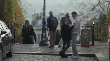 PARIS, FRANCE - 16 ARALIK 2025 - Paris 'te bir kaldırım taşı caddesinde genç bir çift konuşuyor ve kucaklaşıyorlar