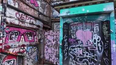 LONDON, İngiltere - 8 Ocak 2026 - Renkli grafiti ve tuğla duvarlar ve metal kepenkler üzerinde soyut duvar resimleri bulunan kentsel alan