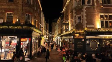 LONDON, UK - 8 HAZİRAN 2026 - İnsanlar Carnaby Caddesi, Londra 'da barları ve dükkanları olan atmosferik sicim lambalarının keyfini çıkarıyorlar