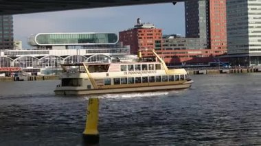 ROTTERDAM, NETHERLANDS - 13 Eylül 2025 - Rotterdam 'da modern şehir binalarıyla birlikte nehir teknesi denize açılıyor