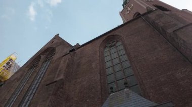 HAGUE, NETHERLANDS - 14 Eylül 2025 Lahey, Hollanda 'da kemerli pencereleri ve kulesi olan uzun tuğlalı gotik kilise