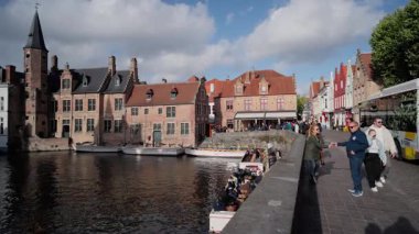 BRUGES, BELGIUM - 15 Eylül 2025 - Tekneli, tarihi tuğla binalı ve güneşli Bruges 'ü seven insanlar