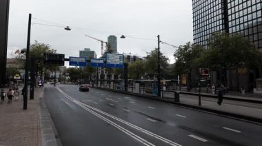ROTTERDAM, NETHERLANDS - 13 Eylül 2025 - Rotterdam 'da trafik işaretleri, arabalar, yayalar ve uzun modern binalar olan şehir caddesi