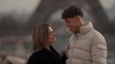 Paris 'te arka planda Eyfel Kulesi olan genç bir çift görülüyor. Aşıklar romantik bir anın tadını çıkarıyorlar. Yavaş çekim ya da sevgi dolu bir çiftin el çekimi olabilir..