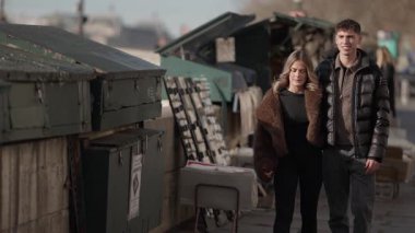 Genç bir çift Paris 'teki Seine Nehri boyunca yürür, klipte eski kitap tezgahlarının ve binaların önünden geçen çiftin orta ölçekli bir fotoğrafı gösterilir..