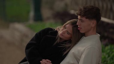 Paris 'te genç bir çift parkta sarılıyor kadın başını erkek arkadaşının omzuna yaslıyor ve el ele tutuşuyorlar..