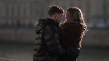 Genç bir çift Paris 'te romantik bir anda kucaklaşıyor. Fransa' da erkek ve kadın, yumuşak doğal aydınlatma ve sığ bir alan derinliği ile samimi bir bağ kuruyor..