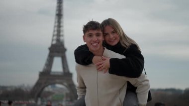 Genç bir çift Paris 'teki Eyfel Kulesi' nin önünde sırtüstü gezerken görülüyor. Adam kadını taşıyor ve ikisi de gülümsüyor ve kucaklıyor. Aşk ve birlikteliğe odaklanmış romantik bir tatil anını yakalıyor..
