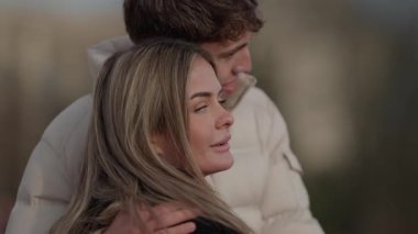 Paris 'te romantik bir çift, Fransa' yı kucaklıyor. Kadın, yumuşak ve sevgi dolu bir ifadeyle omuzlarının üzerinden bakıyor. Sığ bir alan derinliği ve yumuşak bir odaklanma, samimi ve hassas bir an yaratıyor..