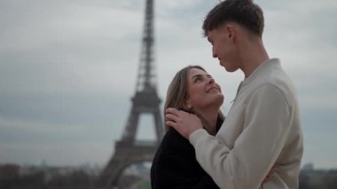 Paris 'te Eyfel Kulesi' nin arka planında romantik bir çift, Paris 'in güzelliğini bir seyahat yeri olarak vurgulayan bir aşk ve bağlantı anını yakalar..